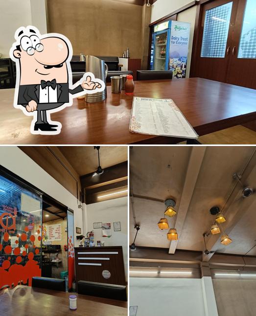 Take a seat at one of the tables at Khana Peena Pure Veg Restaurant