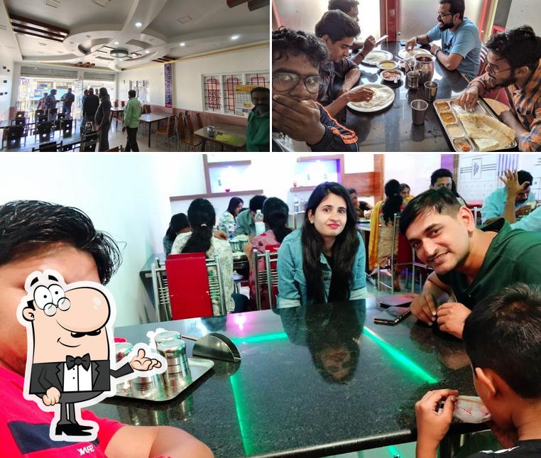 Take a seat at one of the tables at Hotel Welcome Non-Veg