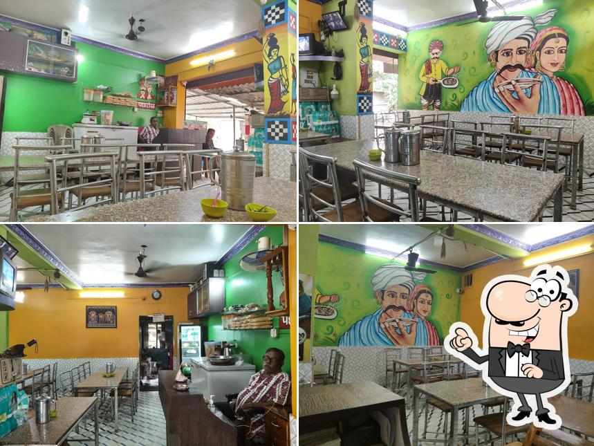 Take a seat at one of the tables at Nirmalya Bhoj, Pure Veg Hotel