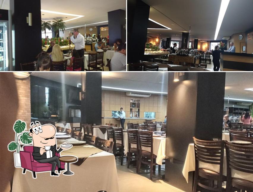 Sente em uma das mesas no Churrascaria Chimarrão
