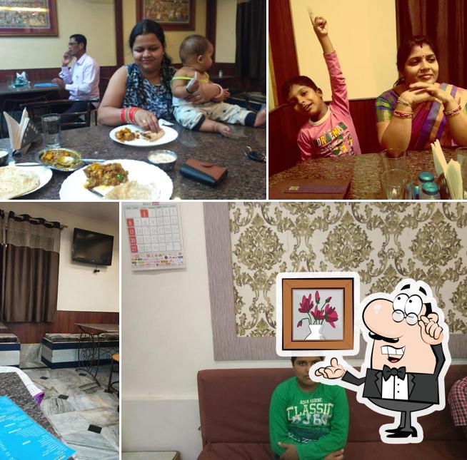 Take a seat at one of the tables at Nandan A/C Veg Restaurant