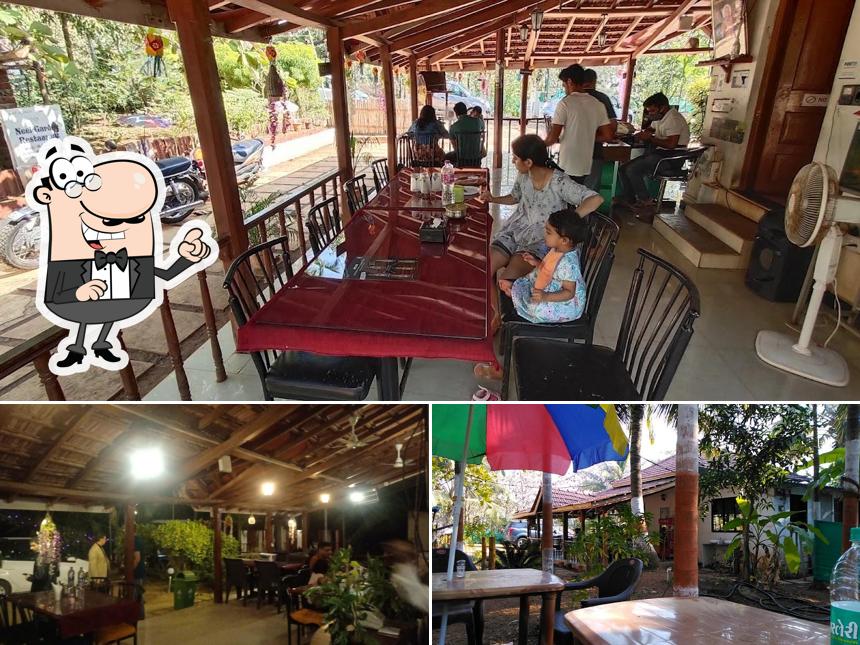 Take a seat at one of the tables at Neel Garden Restaurant And Cottages