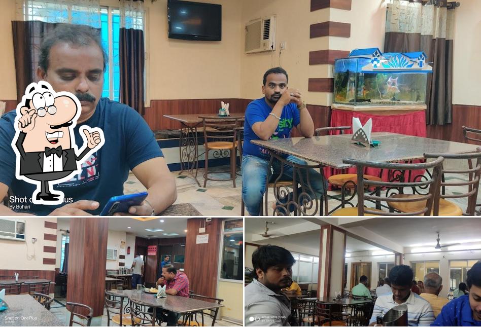 Take a seat at one of the tables at Nandan A/C Veg Restaurant