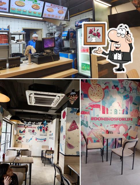 Take a seat at one of the tables at Domino's Pizza Bisrakh Jalalpur, Greater Noida
