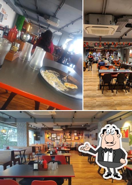 Take a seat at one of the tables at Pizza Zone Habsiguda
