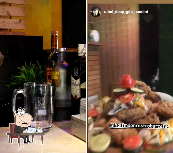 Take a seat at one of the tables at HALF MOON Restro & Cafe bar