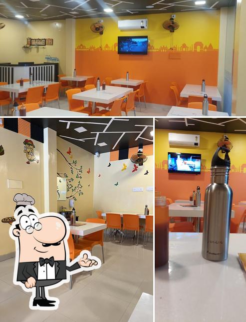 Take a seat at one of the tables at RR PIZZA PARADISE