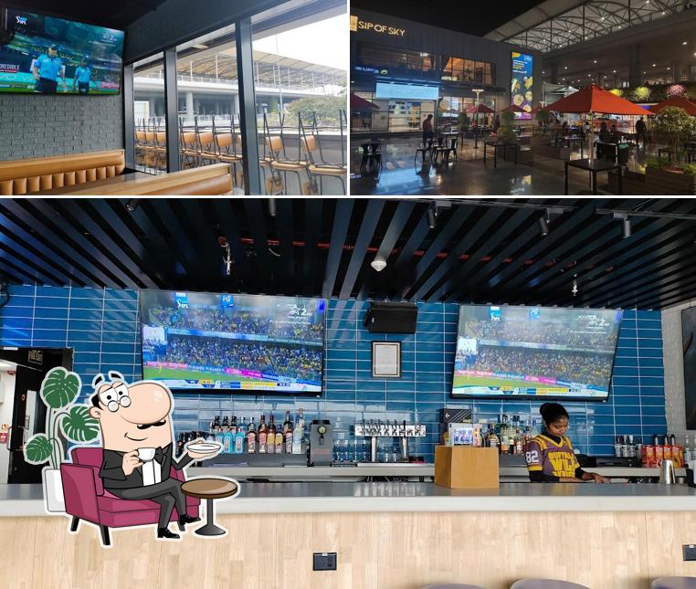 Take a seat at one of the tables at Buffalo Wild Wings (BWW Hyderabad Airport)