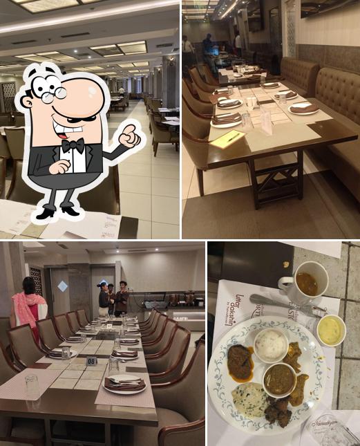 Take a seat at one of the tables at Naivedhyam Restaurant