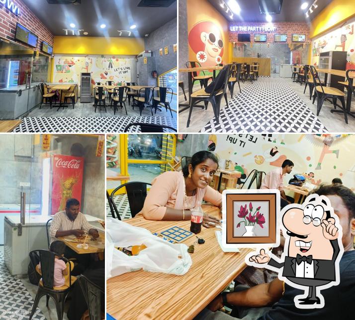 Take a seat at one of the tables at Oyalo Pizza villapuram