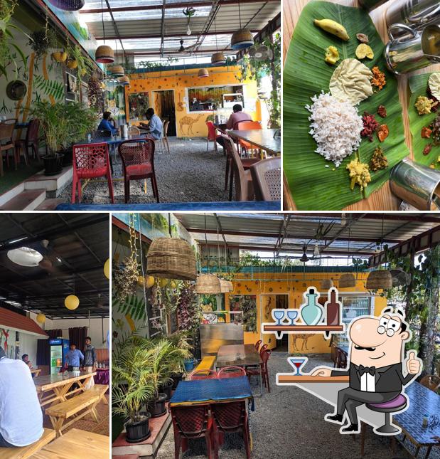 Take a seat at one of the tables at TUSKER CAF'E Restaurant Thekkady