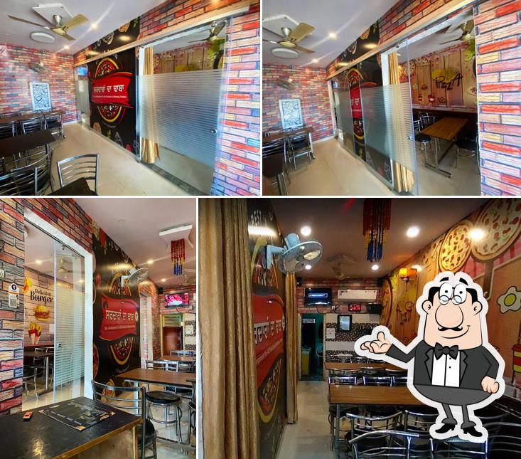 Take a seat at one of the tables at Sardaran Da Dhaba - Best Kulcha Hut In Amritsar Best Pizza Hut In Amritsar