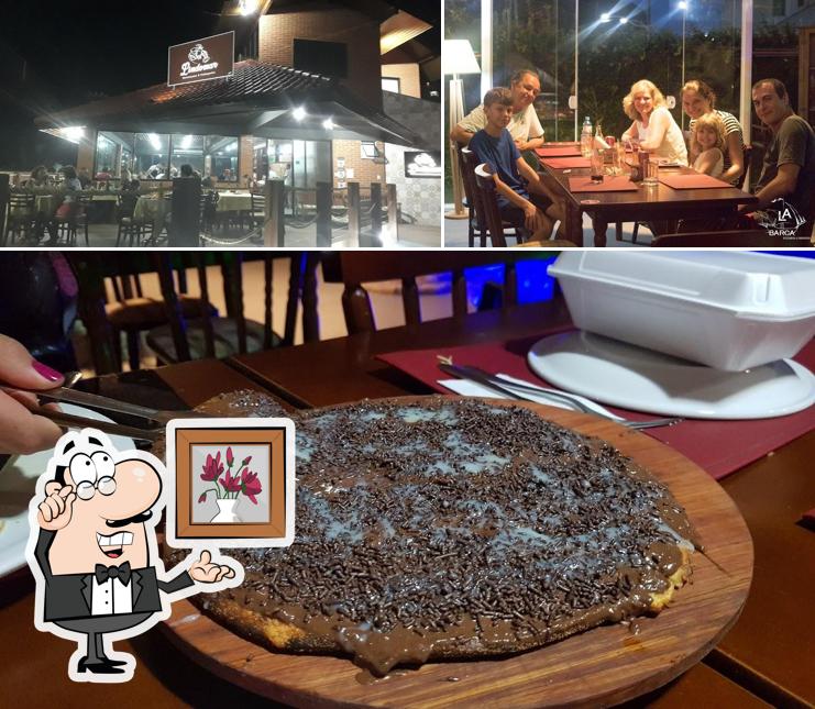 Sente em uma das mesas no La Barca Restaurante e Pizzaria