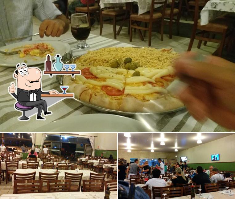 Sente em uma das mesas no Bella Roma Pizzaria e Esfiharia