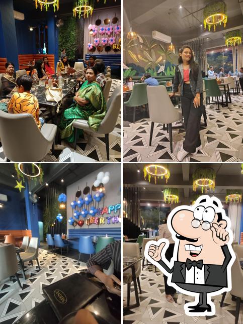 Take a seat at one of the tables at Ravenous Multi Cuisine Restaurant