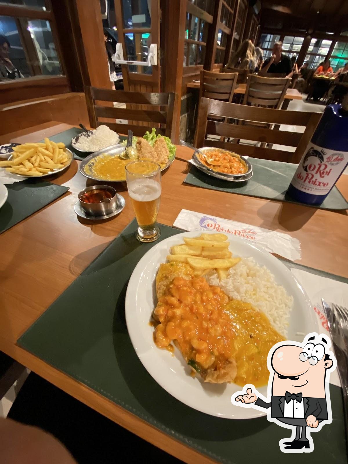 Sente em uma das mesas no Restaurante O Rei do Peixe.