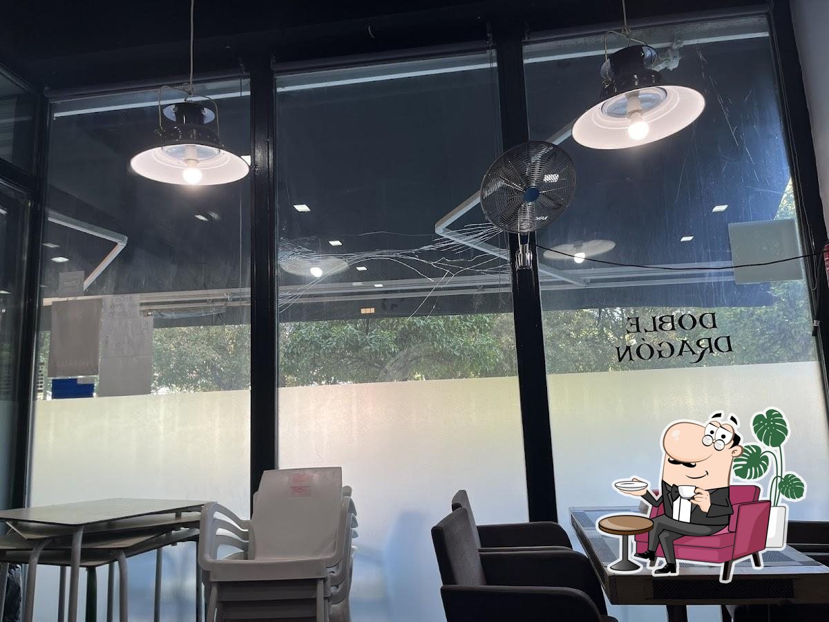 Siéntate a una de las mesas de Restaurante Bar Chino Doble Dragón.