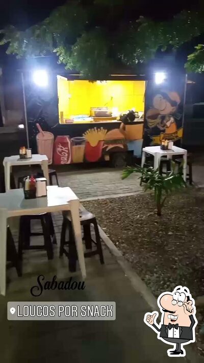 Sente em uma das mesas no Loucos por Snack food truck