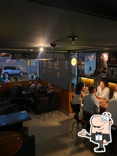 Sente em uma das mesas no Old Street Bar e Tattoo