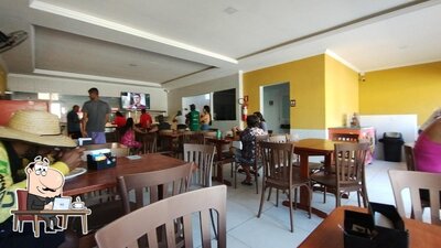 Sente em uma das mesas no Encontro do Sabor Restaurante & Pizzaria