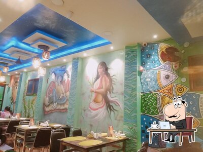 Take a seat at one of the tables at KALAPATA AC family Restaurant