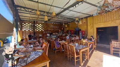 Sente em uma das mesas no Villarejo Cafeteria, Empório e Restaurante