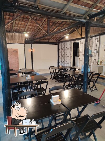 Sente em uma das mesas no Vila Pizzaria