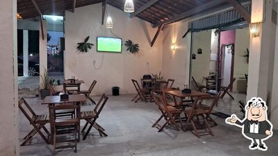 Sente em uma das mesas no Berguim Restaurante e Petiscaria