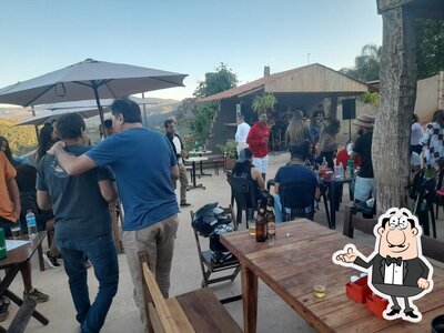 Sente em uma das mesas no Bar e Espeteria do Claudinho