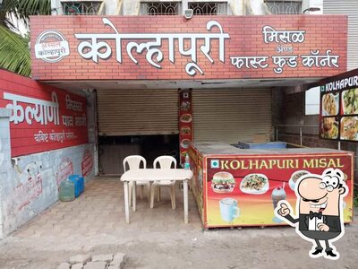 Take a seat at one of the tables at Kolahapuri Misal And Fast Food