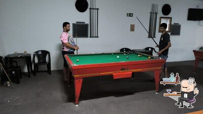 Sente em uma das mesas no Clube da Sinuca