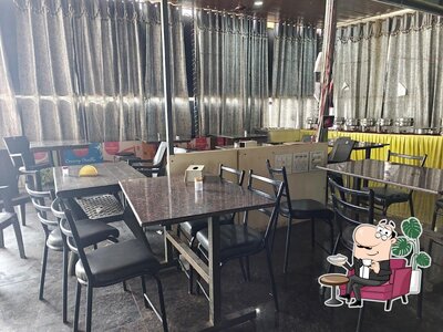 Take a seat at one of the tables at Srinu Restaurant