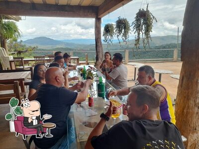 Sente em uma das mesas no Bar e Espeteria do Claudinho
