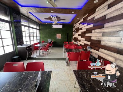 Take a seat at one of the tables at Pizzmo (fastfood & Restaurant)