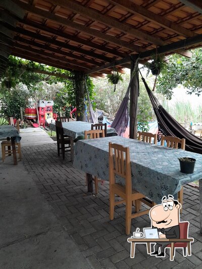Sente em uma das mesas no Sabor da Ilha Bar e Restaurante