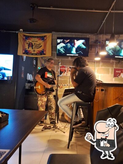 Sente em uma das mesas no Old Street Bar e Tattoo