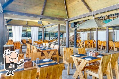 Take a seat at one of the tables at The Gazebo World Of Veg - Veg Restaurant Wakad