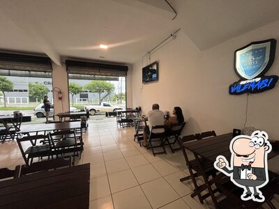 Sente em uma das mesas no Village hamburgueria e pizzaria