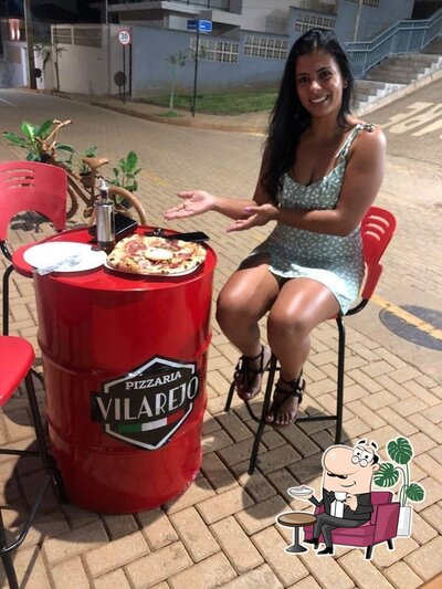 Sente em uma das mesas no Pizzaria Vilarejo