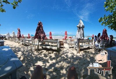 Sente em uma das mesas no Cabana Silvana E Cia Praia