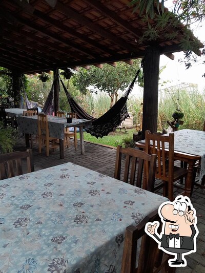 Sente em uma das mesas no Sabor da Ilha Bar e Restaurante
