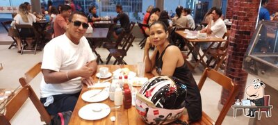 Sente em uma das mesas no Pizzaria e Panificadora Varandas
