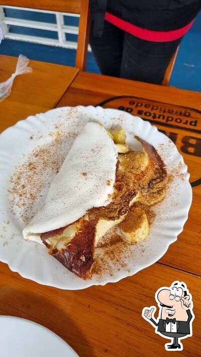 Sente em uma das mesas no Papagaios Restaurante e Tapiocaria