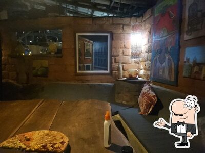 Sente em uma das mesas no Pizzaria Roberto e Sheila