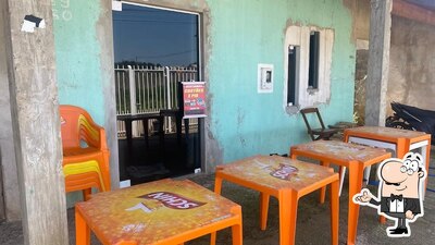 Sente em uma das mesas no Recanto da Sil Grillos Bar