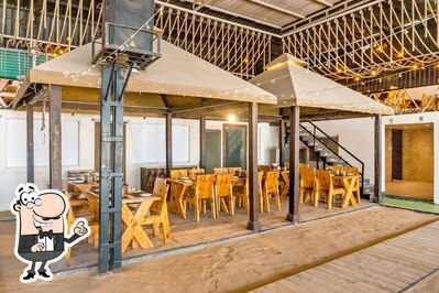 Take a seat at one of the tables at The Gazebo World Of Veg - Veg Restaurant Wakad