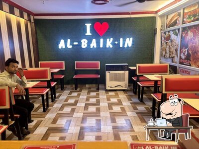 Take a seat at one of the tables at Al - Baik . In