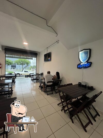Sente em uma das mesas no Village hamburgueria e pizzaria