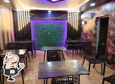 Take a seat at one of the tables at Kamala Rasoi Veg Restaurant