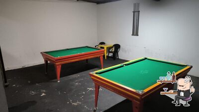 Sente em uma das mesas no Clube da Sinuca